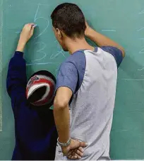  ?? Lalo de Almeida/folhapress ?? O professor Renato explica para um aluno uma operação de matemática durante aula na escola