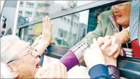  ?? KPPA/AFP ?? North Koreans (in the bus) grip hands of their South Korean relatives as they bid farewell after a separated family reunion meeting at the Mount Kumgang resort on the North’s southeaste­rn coast on October 22, 2015.