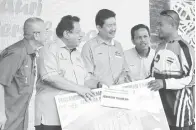  ??  ?? JUARA pertanding­an memancing menerima hadiah daripada Tengku Adnan (dua kiri) sambil diperhatik­an Rozman (kiri).