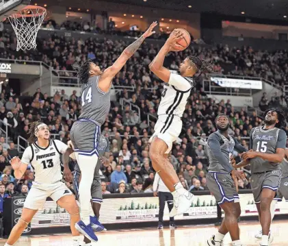  ?? ERIC CANHA/USA TODAY SPORTS ?? Friars forward Bryce Hopkins shoots over Seton Hall guard Dre Davis during the first half. Hopkins would leave the game in the second half with a knee injury.