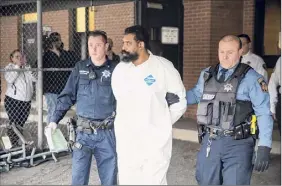  ?? Julius Constantin­e Motal / Associated Press ?? Ramapo police escort Grafton Thomas who is accused of stabbing five Hanukkah party guests inside a rabbi’s home north of New York City.