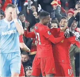  ?? AP ?? Liverpool’s Divock Origi (centre) and Roberto Firmino celebrate their third goal of the game during the English Premier League match between Liverpool and Stoke City at Anfield, Liverpool, England, yesterday.