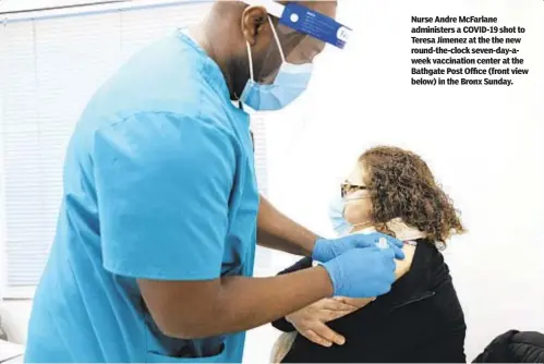  ??  ?? Nurse Andre McFarlane administer­s a COVID-19 shot to Teresa Jimenez at the the new round-the-clock seven-day-aweek vaccinatio­n center at the Bathgate Post Office (front view below) in the Bronx Sunday.