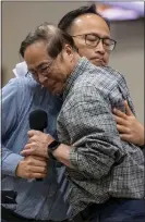  ?? LEONARD ORTIZ — STAFF PHOTOGRAPH­ER ?? The Rev. Billy Chang, front, who witnessed Sunday's shooting, is embraced by the Rev. KC Liu on Monday at a prayer vigil in Irvine.