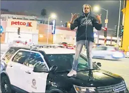  ?? ?? Funny business: Comedian Dave Chappelle’s alleged attacker, Isaiah Lee, stands on a cop car in the YouTube video for his rap track ‘Chappell.’