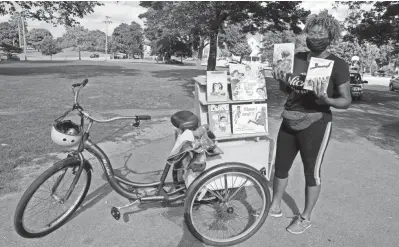  ?? RICK WOOD/MILWAUKEE JOURNAL SENTINEL ?? Cetonia Weston-Roy gathers books she reads to children at Carver Park in this 2020 photo. Her plan to open Niche Book Bar, a bookstore/coffeehous­e/wine bar, is proceeding.