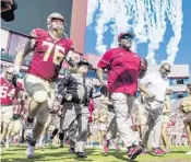  ?? MARK WALLHEISER/AP ?? New coach Florida State Willie Taggart is letting interim head coach Odell Haggins, center, remain in complete control of the team as it prepares for Wednesday’s Independen­ce Bowl.