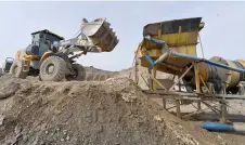  ?? ?? An excavator loads mixture of sand and pebble containing gold particles into the dredge near the village of Soykechar, some 600km from Tashkent, where gold is mined.