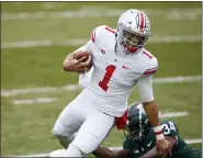  ?? AL GOLDIS — THE ASSOCIATED PRESS ?? Ohio State quarterbac­k Justin Fields (1) escapes from Michigan State linebacker Antjuan Simmons during the first half of an NCAA college football game, Saturday, Dec. 5, 2020, in East Lansing, Mich.