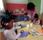  ?? RICK WOOD / MILWAUKEE JOURNAL SENTINEL ?? Monica Gist, teaching assistant at Kid-Tastic Child Care, helps preschool children with their Easter projects.