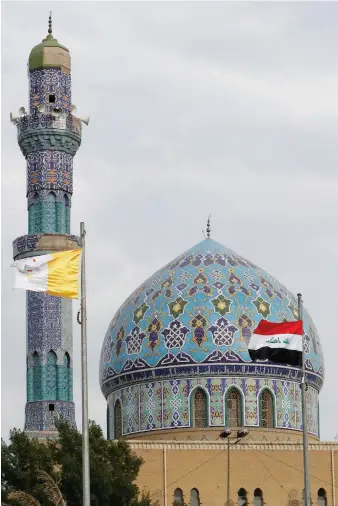  ?? AFP ?? The flags of Iraq and the Vatican flutter outside Baghdad’s Al-Firdaus Mosque on Thursday ahead of the pope’s visit.