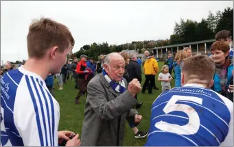  ??  ?? Patsy Vickers offers his congratula­tions to some Éire Óg footballer­s after the final whistle.