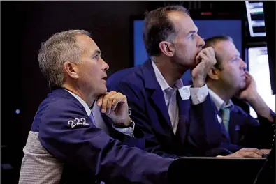  ?? AP/RICHARD DREW ?? Traders work Wednesday on the floor of the New York Stock Exchange where stocks rallied almost 2 percent, recovering some of Tuesday’s losses.