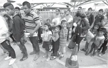  ?? Associated Press ?? ■ Immigrant families line up Sunday to enter the central bus station after they were processed and released by U.S. Customs and Border Protection, Sunday in McAllen, Texas.