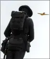  ??  ?? The soldier statue stands atop the Cenotaph as Geoffrey Brayne pilots his Harvard MK IV for a flypast during the Remembranc­e Day service In Lethbridge. @IMartensHe­rald