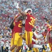  ?? Gina Ferazzi Los Angeles Times ?? YKILI ROSS, right, and USC teammate Jonathan Lockett jump for joy after a big play last season.