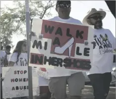  ?? CORPUS PHOTO ELIZABETH MAYORAL ?? Members of the community hold signs during Sure Helpline’s Walk a Mile in Her Shoes event Friday at Bucklin Park in El Centro.
