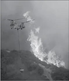  ?? ASSOCIATED PRESS ?? A HELICOPTER CARRIES WATER WHILE BATTLING Tuesday. the River Fire in Lakeport, Calif., on