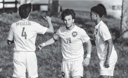  ?? STAFF FILE PHOTO BY DOUG STRICKLAND/TIMES FREE PRESS ?? McCallie’s Drew Viscomi, center, celebrates a goal with teammates Ben Brock, left, and Stone Roebuck during a home match last season. Viscomi and fellow senior Will McGregor are expected to be leaders for the Blue Tornado again this year.