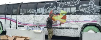  ??  ?? L’artiste Shantz réalise une oeuvre sur l’autobus du Festival Inspire. − Acadie Nouvelle: Sylvie Mousseau