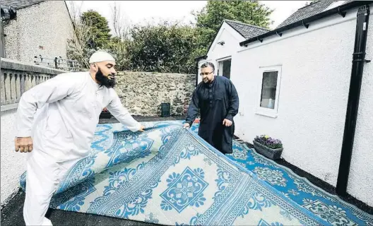  ?? JEFF J MITCHELL / GETTY ?? Inauguraci­ón. Dos miembros de la comunidad musulmana de
Stornoway despliegan una alfombra en la mezquita. Abajo, el imán Abderraman Mangera