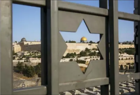  ?? ODED BALILTY — THE ASSOCIATED PRESS ?? Jerusalem’s Old City is seen trough a door with the shape of star of David, Tuesday. Israel has begun dismantlin­g metal detectors it installed a week earlier at the gates of a contested Jerusalem shrine, amid widespread Muslim protests.