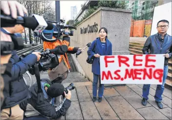  ?? CP PHOTO ?? People hold a sign at a B.C. courthouse prior to the bail hearing for Meng Wanzhou, Huawei’s chief financial officer, on Monday.