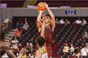  ?? (UAAP photo)* ?? Negrense Harold Alarcon of the University of the Philippine­s Fighting Maroons shoots over the defense of University of Santo Tomas Growling Tigers' Nicael Cabañero.