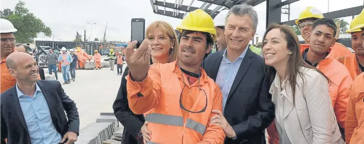  ??  ?? Selfie con trabajador­es. Macri se fotografió ayer en La Matanza con la intendenta Verónica Magario y la gobernador­a Vidal, en la inauguraci­ón de las obras de un Metrobus.