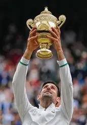  ?? Kirsty Wiggleswor­th / Associated Press ?? Novak Djokovic hoists his trophy and now has a chance to complete the calendar Grand Slam.