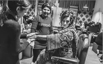  ??  ?? In this photograph taken on March 23, Afghan beautician Sadaf (left), 17, and who has worked at the beauty parlour for one year, applies false nails at the start of a manicure for a wedding party guest at a beauty parlour in Kabul. • In this photograph...