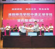  ?? PROVIDED TO CHINA DAILY ?? BFV vice-chairman Gerd Liesegang, Zhu Linsheng (center), principal of Huaiyin Normal University, and Hu Liangping, CEO of Hamsum Sports, shake hands during the opening ceremony for the Sino-German Football Academy in Huaian, Jiangsu province, last...