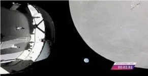  ?? — AP ?? Space adventure: A screencap from Nasa TV showing the Orion capsule (left) nearing the moon. In the middle is Earth.