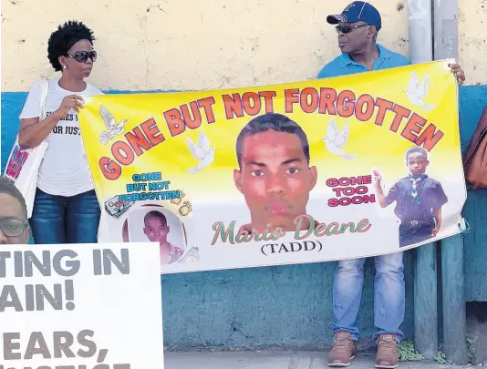  ?? PHOTOS BY ADRIAN FRATER ?? Mercia Fraser (left) holding a banner with a portrait of her son, Mario Deane. AT LEFT: A protester calls for justice for Mario Deane five years after his death.