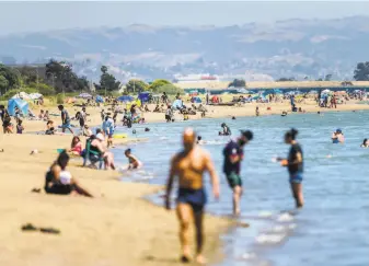  ?? Noah Berger / Special to The Chronicle ?? Beachgoers gather at Robert W. Crown Memorial Beach in Alameda in May. Public health officials say large public gatherings are a common source of coronaviru­s infections.