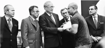  ??  ?? Riot (third left) presents the aid contributi­on to a recipient Zaidi Omar (second right) at the Employment Insurance System (SIP) interim aid ceremony. — Bernama photo