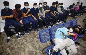  ?? The Associated Press ?? ■ In this March 30 photo, young unaccompan­ied migrants wait for their turn at the secondary processing station inside the U.S. Customs and Border Protection facility, the main detention center for unaccompan­ied children in the Rio Grande Valley, in Donna, Texas. U.S. authoritie­s say they picked up nearly 19,000 children traveling alone across the Mexican border in March. It’s the largest monthly number ever recorded.