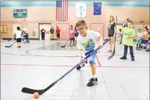  ??  ?? A young boy takes a shot at a goal during Tuesday’s street hockey clinic.