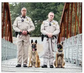  ?? COURTESY OF FAULKNER COUNTY SHERIFF’S OFFICE ?? Faulkner County Sheriff’s Office patrol deputies Keenan Wallace, left, handler for canine officer Timon, and Adam Cox, handler for Terry, are pictured on the Springfiel­d-Des Arc Bridge in Beaverfork Park in Conway. The dogs are the latest addition to...