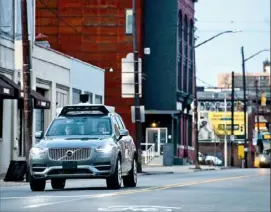  ?? Stephanie Strasburg/Post-Gazette ?? In a 2017 photos, operators ride inside one of Uber’s self-driving SUVs along Penn Avenue in the Strip District.
