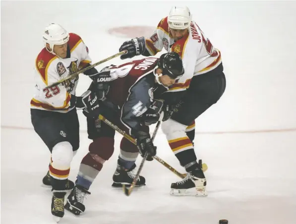  ?? — GLENN CRATTY, GETTY IMAGES FILES ?? Florida Panthers defenceman Ed Jovanovski and teammate Johan Garpenlov put the squeeze on Colorado Avalanche winger Scott Young during Game 4 of the 1995-96 Stanley Cup Final at Miami Arena. The third-year franchise was swept by the Avalanche.