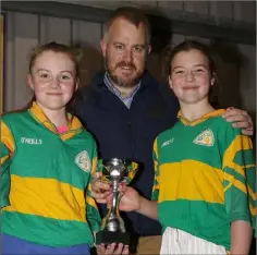  ??  ?? Joint captains Clarisse Ní Chonchubha­ir and Sorcha Ní Mhurchú receiving the trophy from Johnny Murphy (Rackard League Secretary).