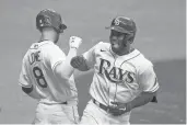  ?? CHRIS O’MEARA/AP ?? The Rays’ Randy Arozarena celebrates his solo home run off Yankees starting pitcher Domingo German with second baseman Brandon Lowe during the third inning Saturday in St. Petersburg, Florida.