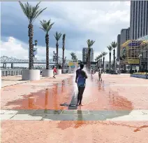  ?? ANDREA SACHS/THE WASHINGTON POST ?? A woman escapes the humidity among the water spouts at Woldenberg Riverfront Park.