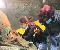  ?? LUIGI SPINA / VIA REUTERS ?? Archaeolog­ists work on Saturday on an ancient ceremonial carriage uncovered at a dig near the Roman city of Pompeii.
