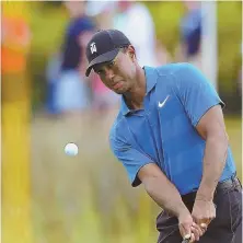  ?? STAFF PHOTO BY CHRISTOPHE­R EVANS ?? CHIPPING AWAY AT IT: Tiger Woods knocks a shot onto the 10th green yesterday at TPC Boston during a practice round for the Dell Technologi­es Championsh­ip.