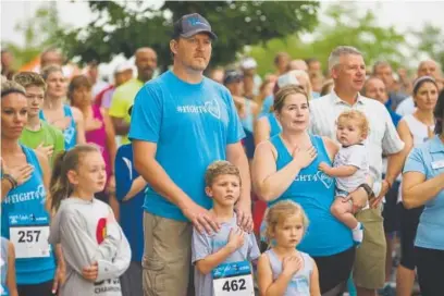  ?? Daniel Brenner, Special to The Denver Post ?? Supporters gather for the national anthem before the Bigelow Strong 5K Fundraiser on Sunday in Westminste­r. The race and a silent auction raised money for the Bigelow family after June’s alleged road rage shooting, which killed Vaughn Bigelow Jr., 13,...