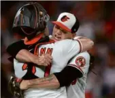  ?? ROB CARR/GETTY IMAGES ?? Tyler Wells (right) and James McCann embrace after the Orioles triumphed.