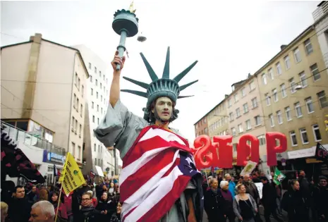  ?? (AP FOTO) ?? TRANSATLAN­TIC GAP. In this April 23, 2016 file picture, a man on stilts and dressed like the Statue of Liberty attends a protest against the planned Transatlan­tic Trade and Investment Partnershi­p (TTIP) ahead of the visit of United States President...