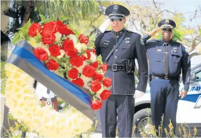  ?? CARLINE JEAN/STAFF PHOTOGRAPH­ER ?? Officer Henry Lugo and Lt. David Weatherspo­on of the Delray Beach Police Department salute fallen officers during the department’s Law Enforcemen­t Officer Memorial Ceremony on Friday.